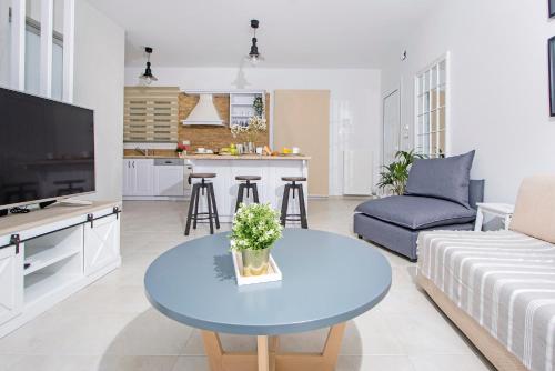 un salon avec une table bleue et une cuisine dans l'établissement Domus Lux Houses by Konnect, à Corfou
