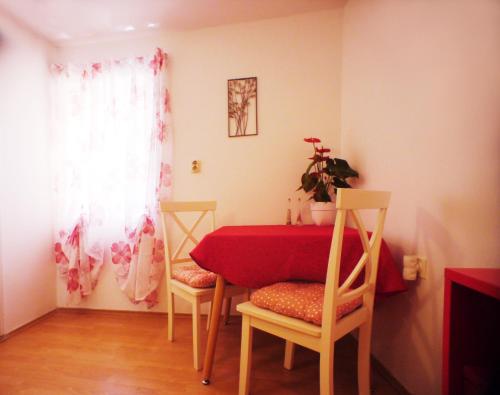 ein Esszimmer mit einem roten Tisch und 2 Stühlen in der Unterkunft Old City in Novigrad Istria