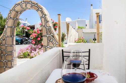 kieliszek wina siedzący na stole na balkonie w obiekcie Christina Rooms w mieście Adamas
