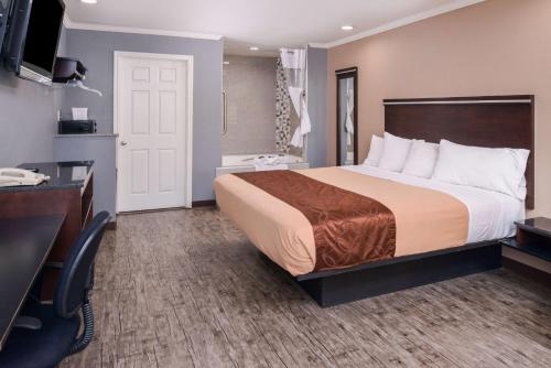 Pokój hotelowy z łóżkiem i biurkiem w obiekcie Laguna Inn and Suites w mieście San Juan Capistrano