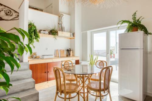 a kitchen and dining room with a table and chairs at Selina Boavista Ericeira in Ericeira