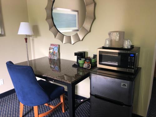 a room with a desk with a microwave and a blue chair at The Black Mountain Inn in Brattleboro