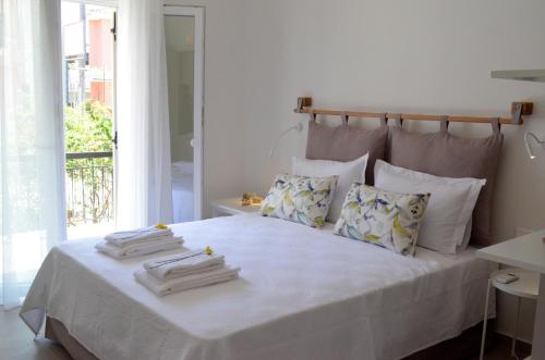 une chambre avec un grand lit avec des draps et des oreillers blancs dans l'établissement Casa MaLu Boutique Apartments - No 1, à Gouviá