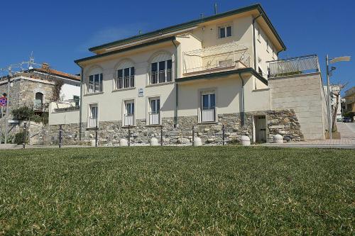 un gran edificio con un campo de césped delante de él en Residence Villa Livia, en San Vincenzo