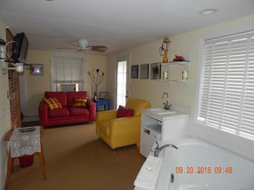 a bathroom with a tub and a living room at Summer Nites in North Wildwood