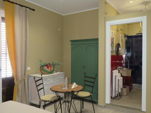 a dining room with a table and chairs and a kitchen at Catria in Favignana