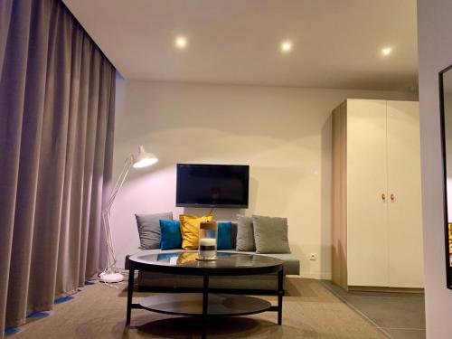una sala de estar con un sofá y una mesa en Suite 336, en Menen
