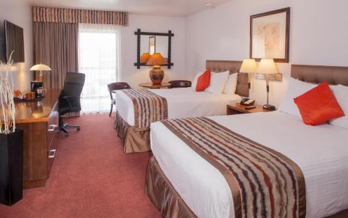 a hotel room with two beds and a desk at Grand Canyon Plaza Hotel-South Rim in Tusayan