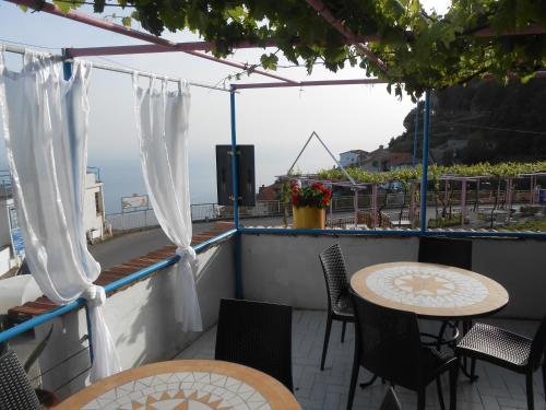 een patio met tafels en stoelen en een luidspreker bij Al Geranio B&B in Furore