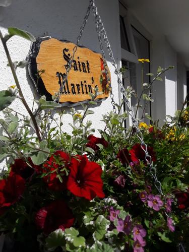a sign that says southatlantic hanging next to flowers at Saint Martin's Bed and Breakfast in Bandon