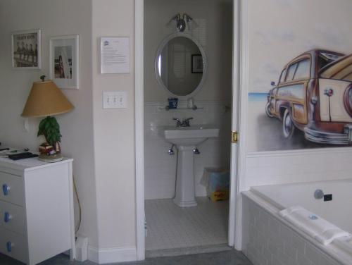a bathroom with a tub and a sink and a mirror at Summer Nites in North Wildwood
