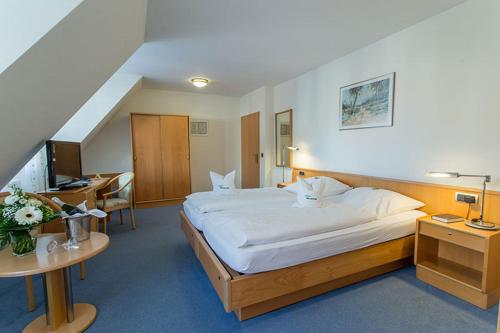 Habitación de hotel con cama grande y escritorio. en Hotel Restaurant Brintrup, en Münster