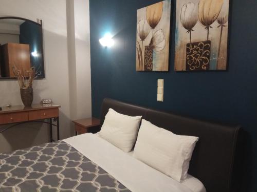 a bedroom with a bed and a blue wall at Zisis Garden Studios in Ioannina