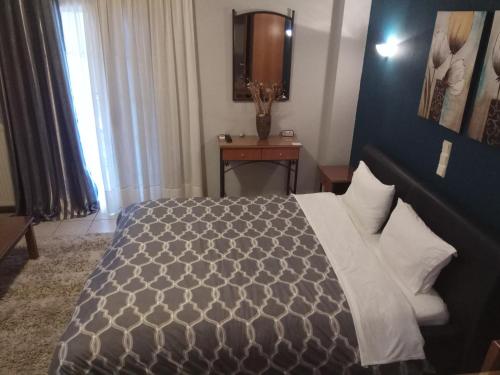 a bedroom with a bed and a table and a mirror at Zisis Garden Studios in Ioannina