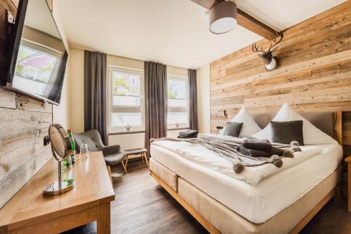 a bedroom with a large bed and a wooden wall at Ferienwohnung HarzReise in Braunlage