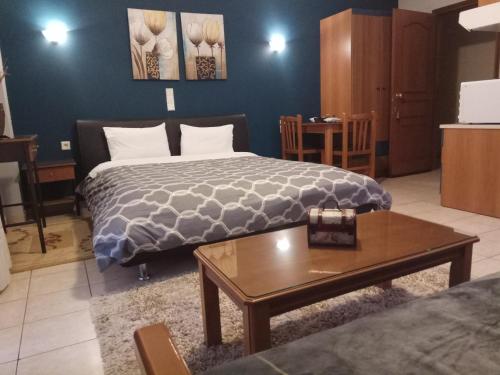 a bedroom with a bed and a coffee table at Zisis Garden Studios in Ioannina