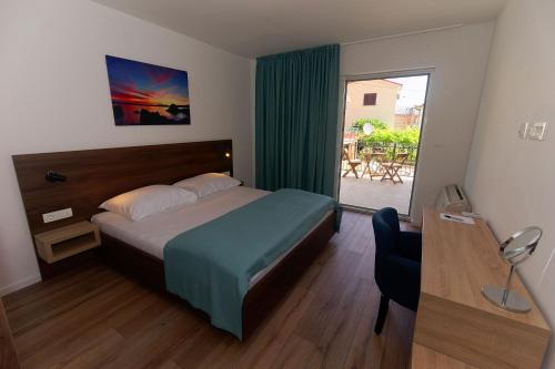 una camera da letto con un letto, una scrivania e una finestra di Villa Nerium a Malinska