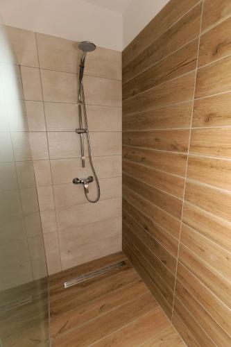 a shower in a bathroom with a wooden wall at Villa Nerium in Malinska