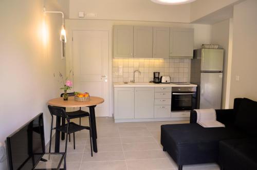 eine Küche und ein Wohnzimmer mit einem Tisch und einem Sofa in der Unterkunft Casa MaLu Boutique Apartments - No 2 in Gouvia