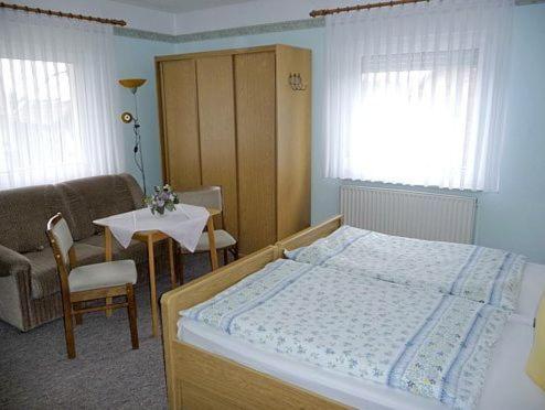 ヴェッチャウにあるHotel-Pension Märkischheideのベッドルーム1室(ベッド1台、テーブル、椅子付)