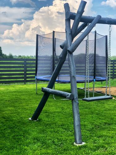 a swing set in the grass with at Pilkas Namelis - Namelių nuoma Šventojoje in Šventoji