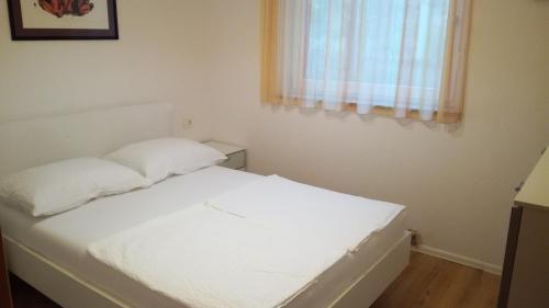 a white bed in a room with a window at VILLA ČEH in Gabrovica pri Črnem Kalu