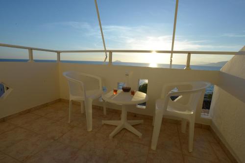 a balcony with a table and chairs on a ship at Nefeli in Kalamaki Heraklion