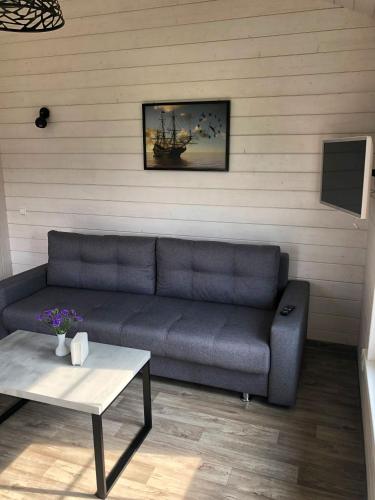 a living room with a couch and a table at Pilkas Namelis - Namelių nuoma Šventojoje in Šventoji