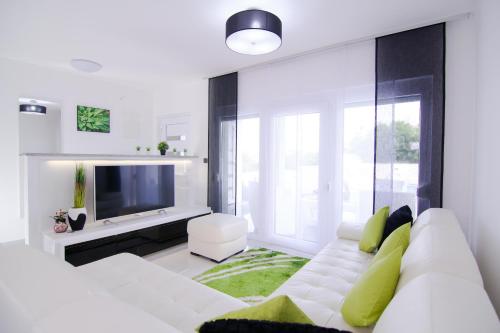 a white living room with a white couch and a tv at LUXURY VILLA BEGANOVIC-VRH in Vrh