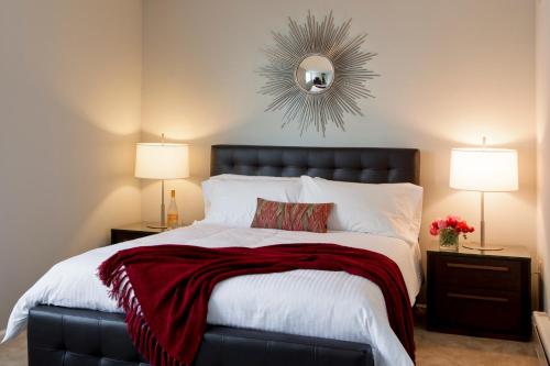 a bedroom with a large bed with a red blanket at Furnished Quarters at 15/25 Bank Street in White Plains