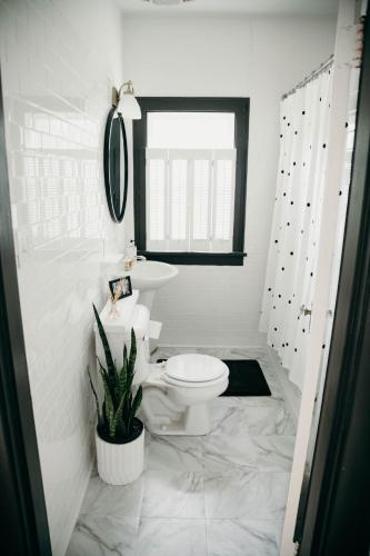 a white bathroom with a toilet and a sink at The Paddock Luxury Vacation Home in Hot Springs