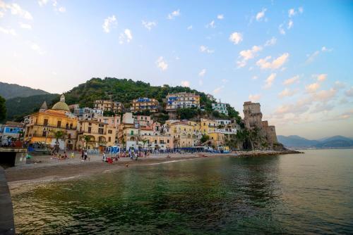 un groupe de bâtiments sur une plage au bord de l'eau dans l'établissement MARINELLA CASA VACANZE, à Cetara