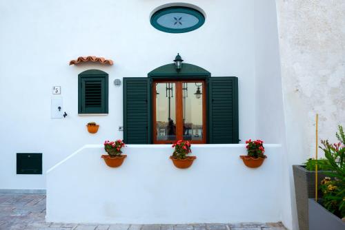 a clock on a white wall with potted plants at MARINELLA CASA VACANZE in Cetara