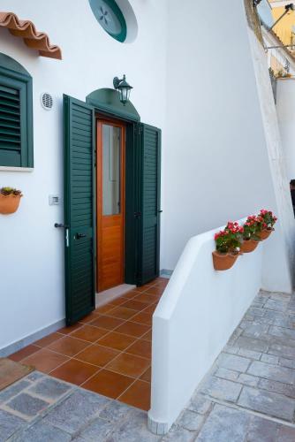 a front door of a white house with green shutters at MARINELLA CASA VACANZE in Cetara