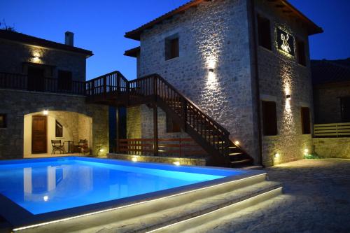 a villa with a swimming pool in front of a building at Elafos Spa Hotel in Elliniko