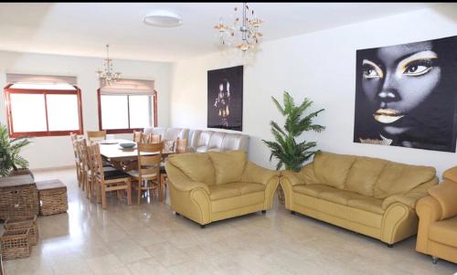 a living room with two couches and a dining room at valentine House in Deir Ḥannā