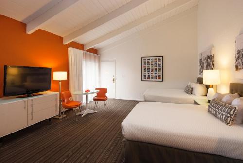 a hotel room with two beds and a flat screen tv at Inn at Venice Beach in Los Angeles