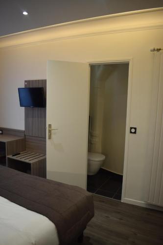 a bedroom with a bed and a bathroom with a toilet at Hotel Puy De Dôme in Paris