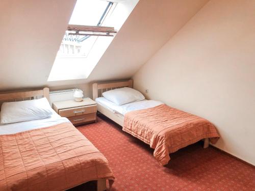 a attic bedroom with two beds and a window at Willa Milano in Mielno