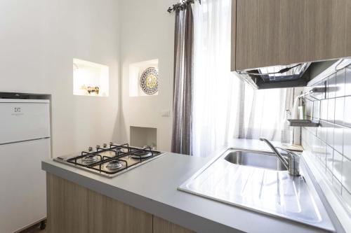 una cucina con lavandino e piano cottura forno superiore di Kate a Leverano