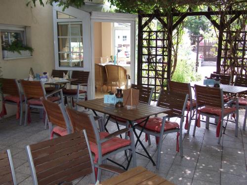 an empty restaurant with wooden tables and chairs at Pension & Café Am Krähenberg in Halle an der Saale
