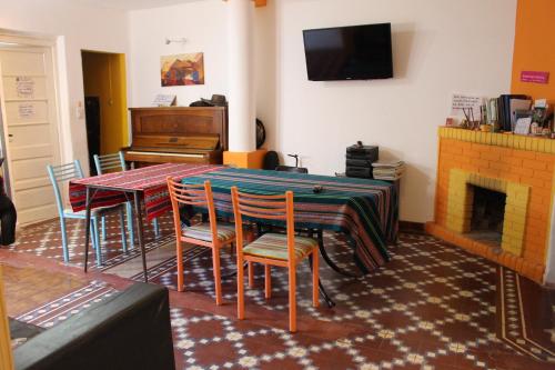 a room with a table and chairs and a piano at Patio de Molina a 100m de la Plaza del Folkore in Cosquín