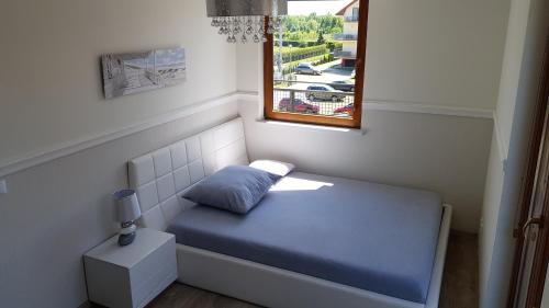 a small bed in a room with a window at APARTAMENT QUEEN KARWIA in Karwia