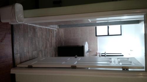 a bathroom with a tub and a sink and a window at El Rancho Motel in Watsonville