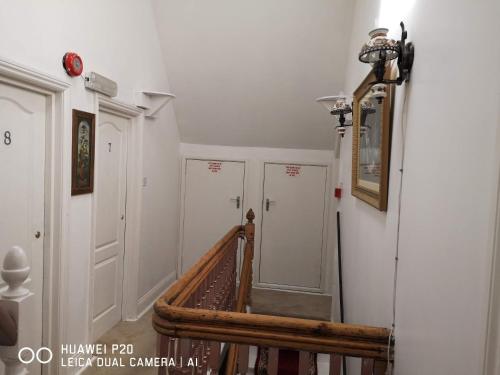 a hallway with a staircase with white walls at Lincoln House in Bournemouth