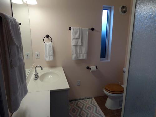y baño con lavabo, aseo y espejo. en Eagle's Nest Resort, en Anahim Lake