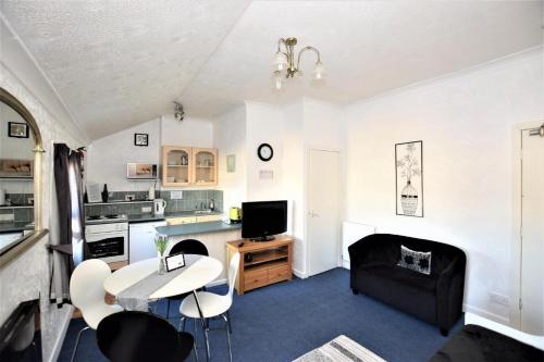 a kitchen and living room with a table and chairs at Bridle Lodge Apartments in Blackpool