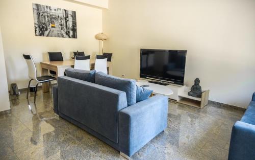 a living room with a blue couch and a tv at Apartamenty Marynarki Wojennej, Dziwnów in Dziwnów