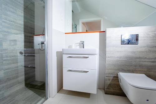 a white bathroom with a sink and a toilet at villa botanica in Niechorze