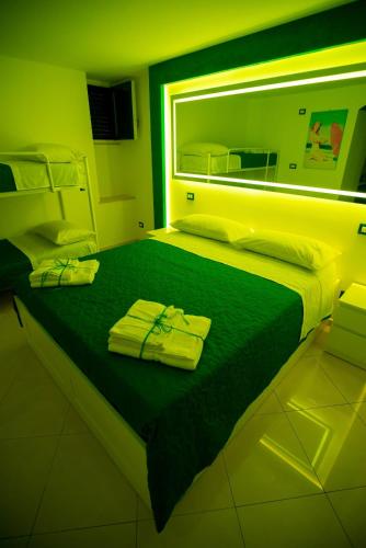 a green room with a bed with towels on it at MARINELLA CASA VACANZE in Cetara